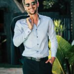 pexels-photo-1043474-1043474 Confident young man in a stylish suit outdoors, exuding charm and elegance.