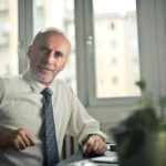 pexels-photo-834863-834863 A mature man in professional attire smiling in an office setting.