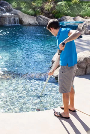 Memorial Pool Services cleaning a pool with a skimmer in Houston, TX